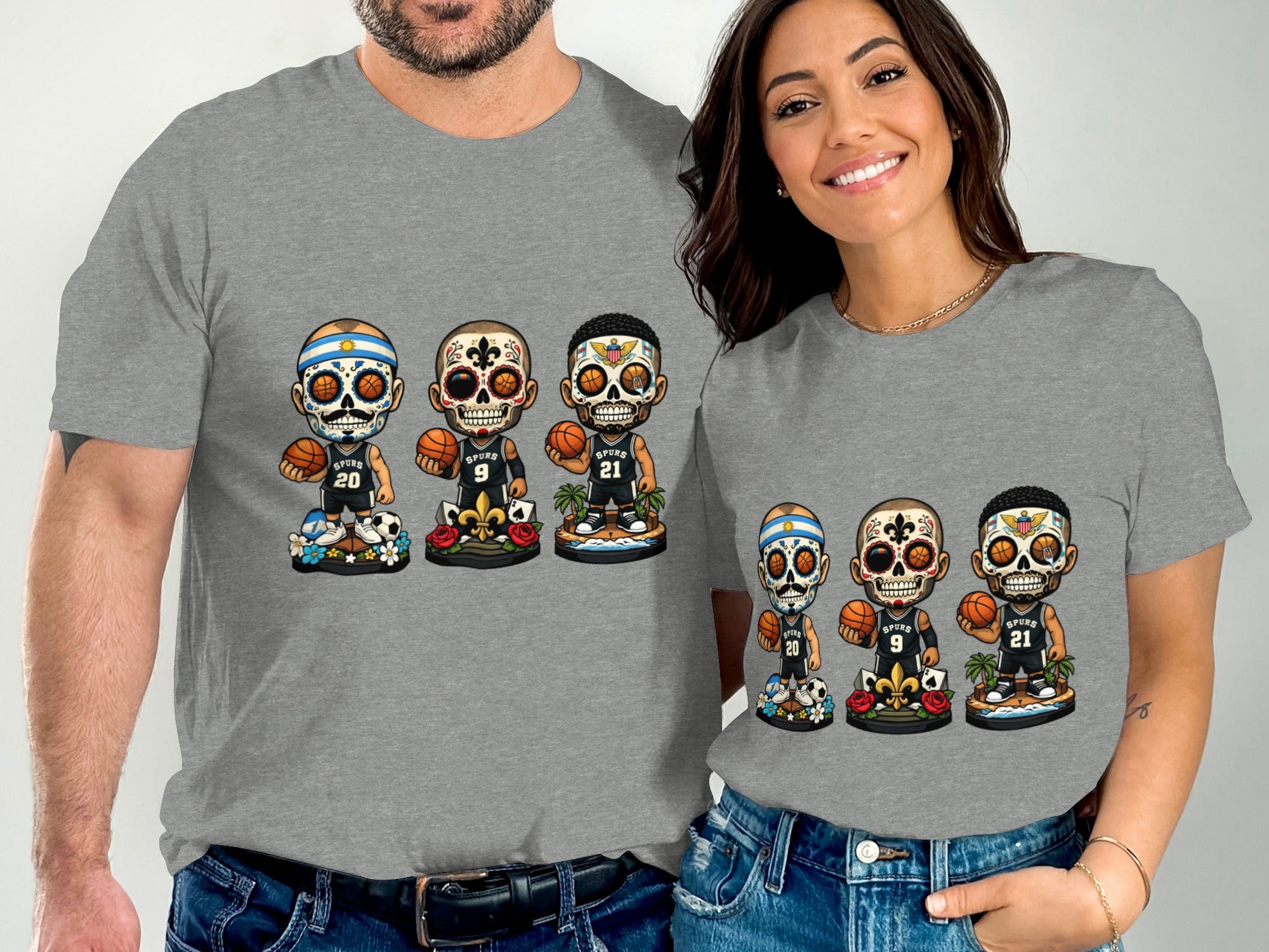 Two people wear grey t-shirts featuring cartoon skeletons in basketball uniforms with sugar skull designs.