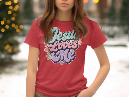 Red t-shirt with "Jesus Loves Me" text graphic in pastel colors and hearts.