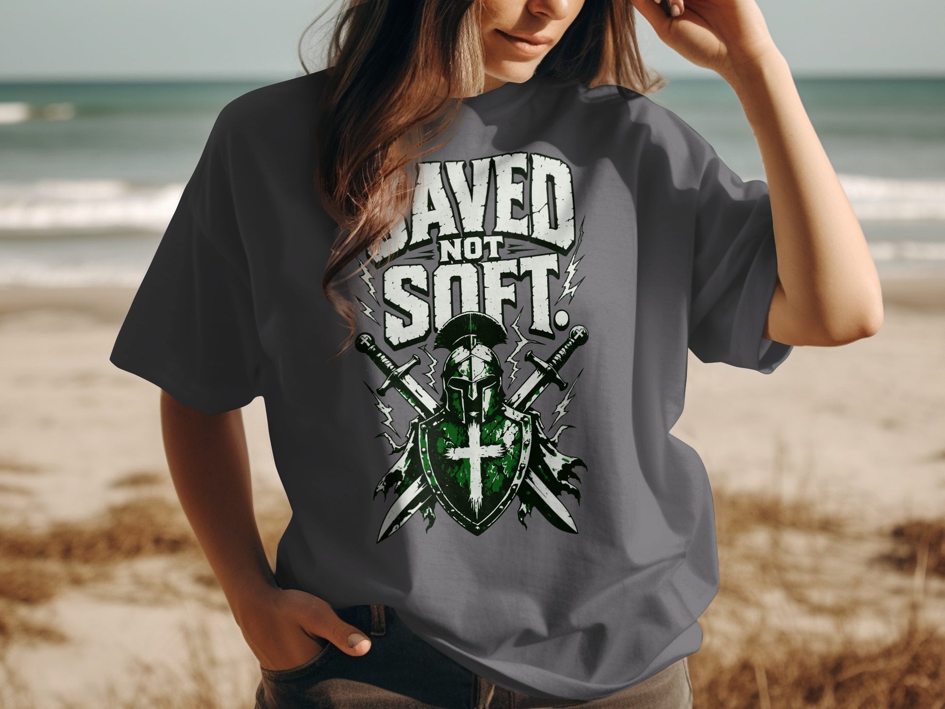 Dark grey t-shirt with "SAVED NOT SOFT" text over knight's helmet, shield, and swords.