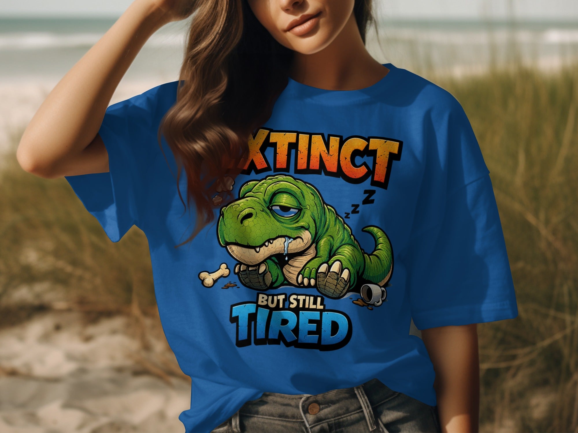 Blue t-shirt with a tired dinosaur graphic that reads "Extinct But Still Tired".