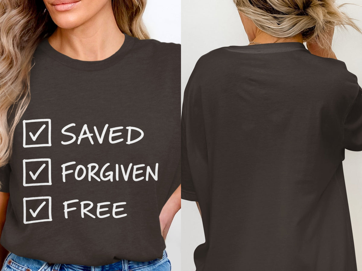 Dark t-shirt with white text: Saved, Forgiven, Free, in a checklist format.