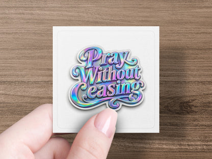 Holographic sticker with "Pray Without Ceasing" text held by fingers