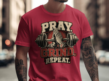 Red t-shirt with "Pray. Grind. Repeat." text, praying hands, and dumbbell graphic.