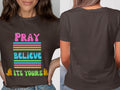 Dark brown t-shirt with "PRAY BELIEVE ITS YOURS" text and praying hands.