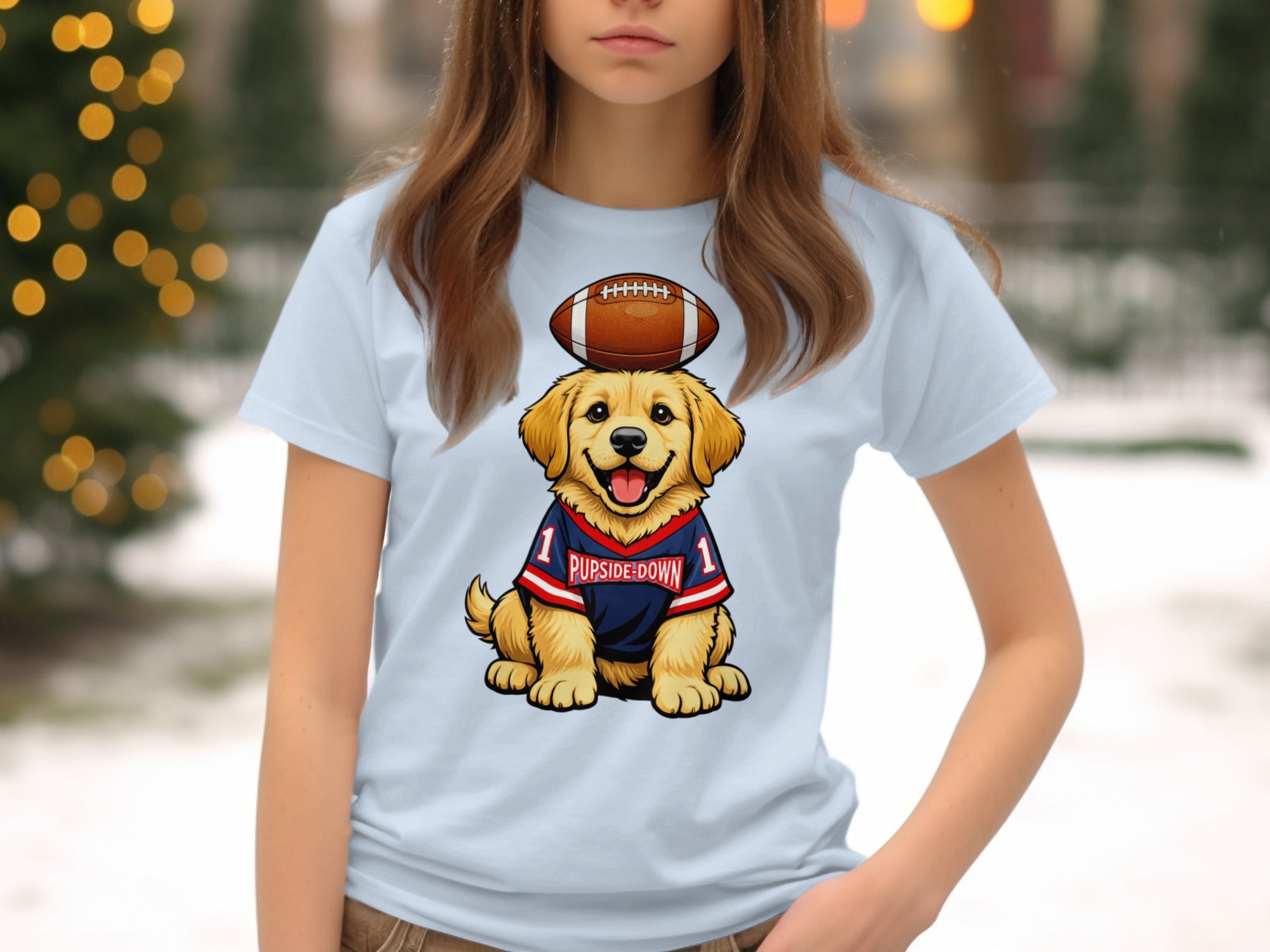 Golden retriever puppy wearing a football jersey with "PUPSIDE-DOWN" and a football on head.
