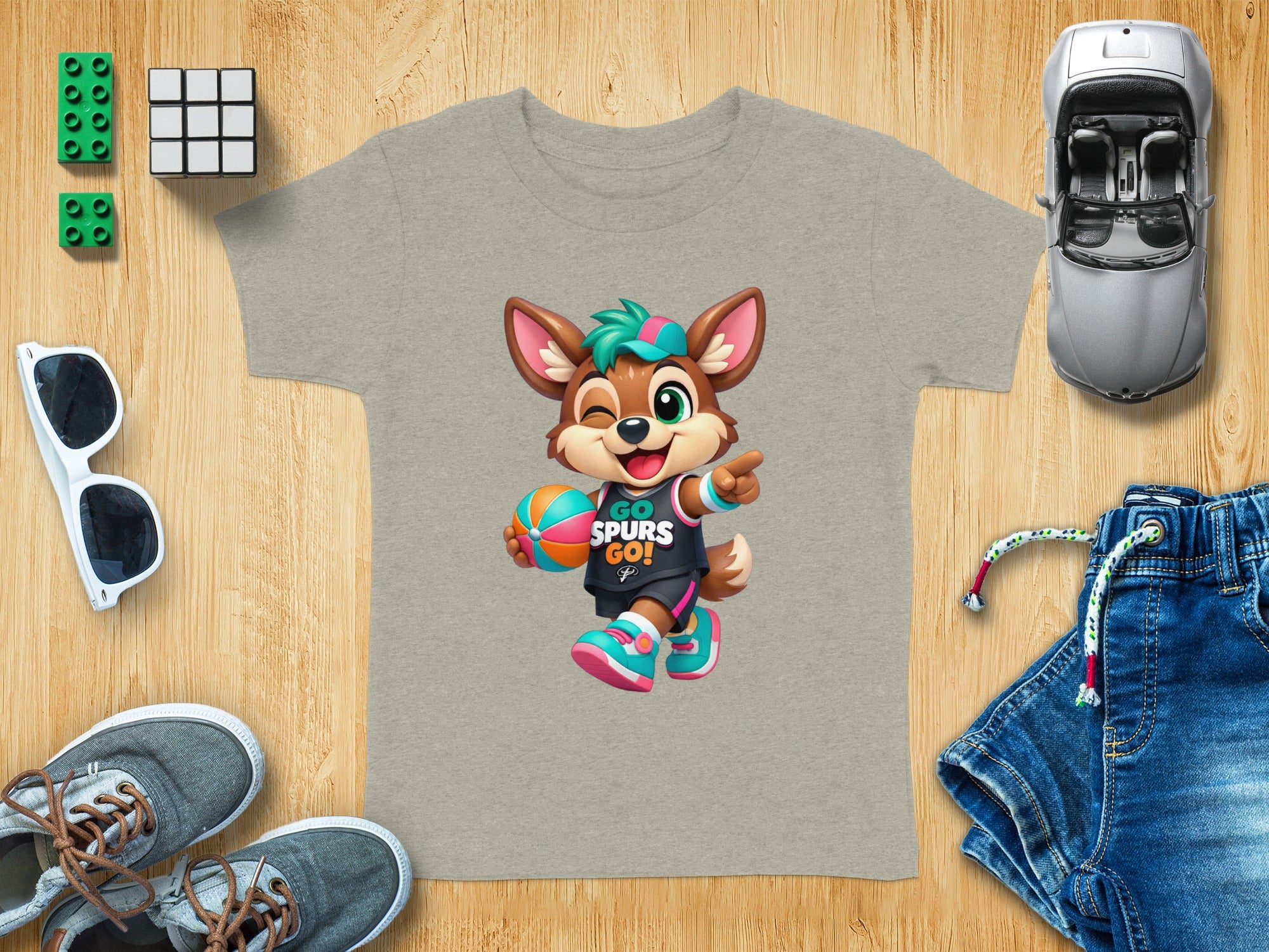 Cartoon fox mascot wearing a "Go Spurs Go!" shirt and holding a basketball.