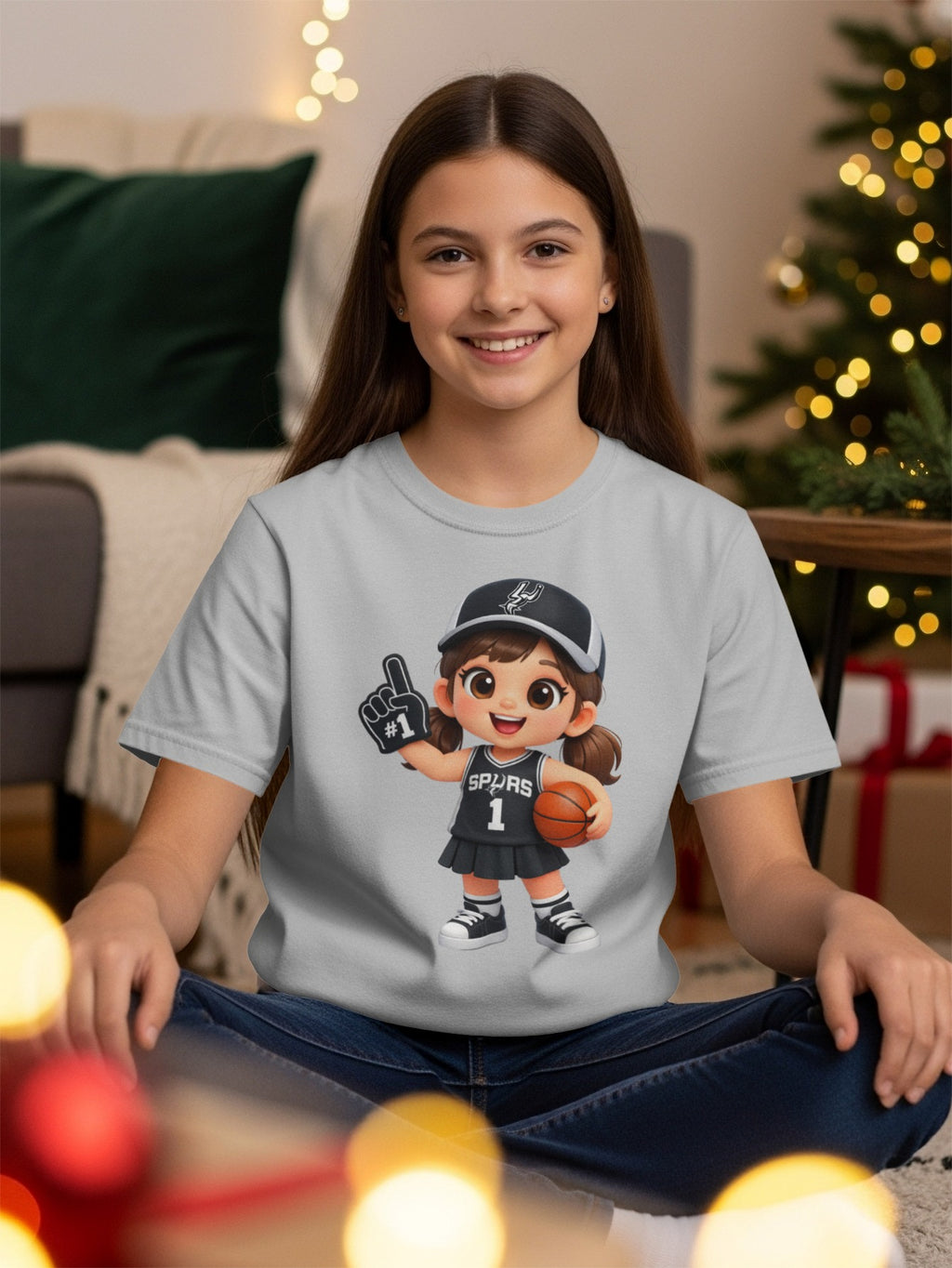 Gray t-shirt with cartoon girl in Spurs basketball uniform holding ball and foam finger.