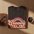 Dark t-shirt with "Groovy Mama" text and rainbow graphic.