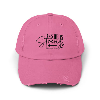 Distressed pink baseball cap with "SHE IS Strong" and "Proverbs 31:25" text.