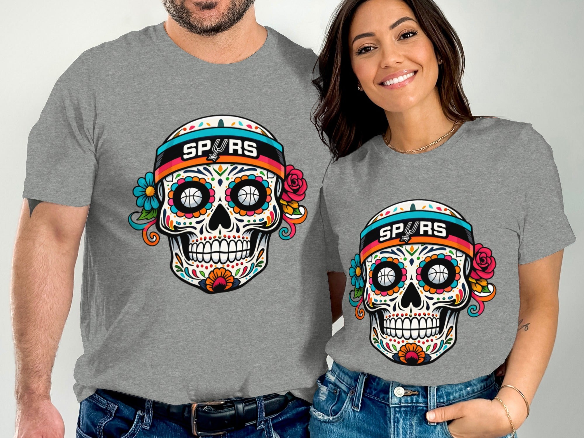 Two grey t-shirts featuring a colorful sugar skull with "SPURS" band and basketball eyes.