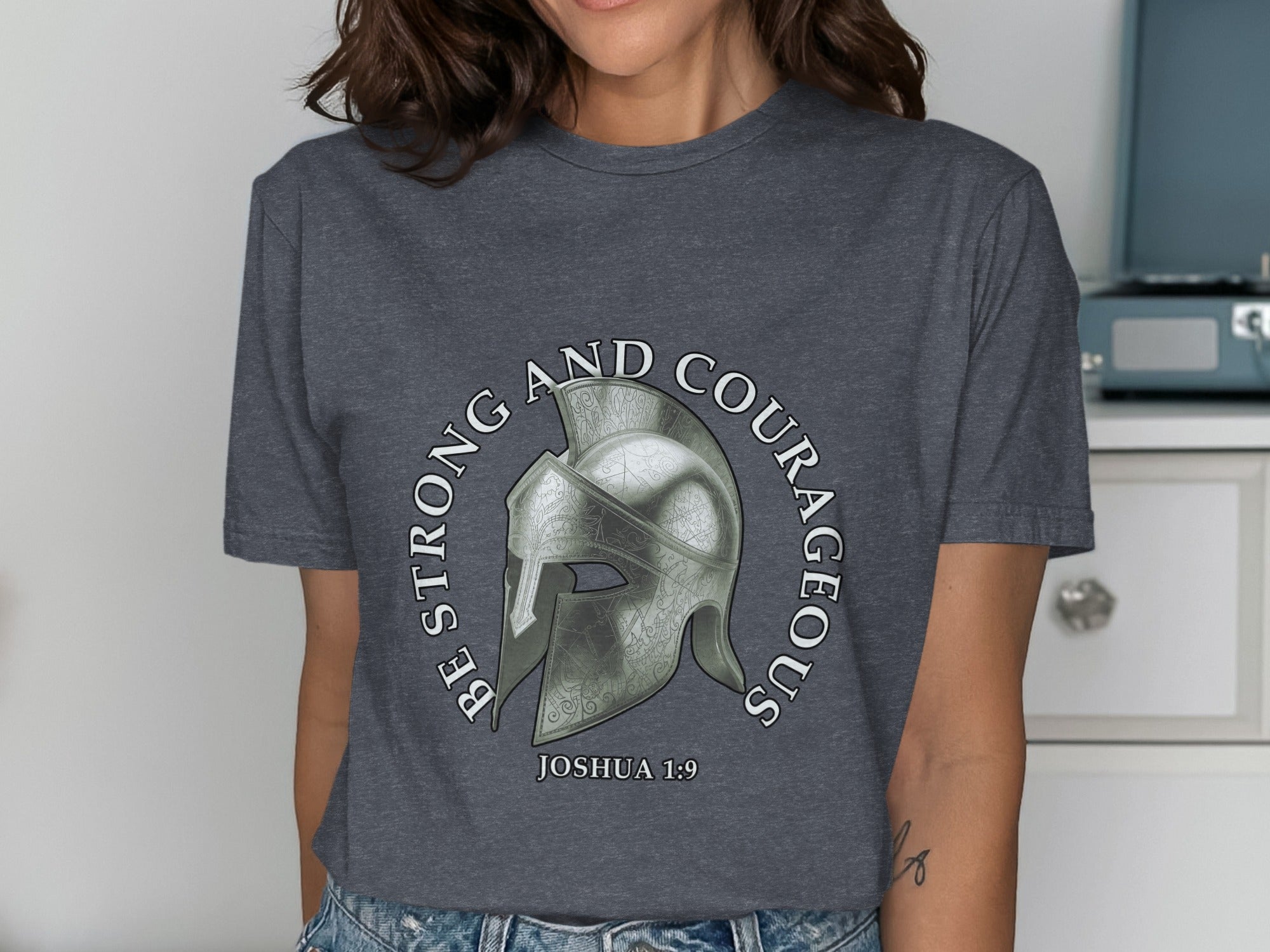 Dark gray t-shirt with a Roman helmet and text "Be Strong and Courageous Joshua 1:9".