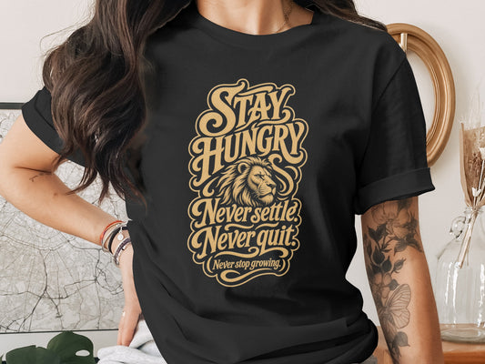 Black t-shirt with gold text: "Stay Hungry Never settle Never quit (Never stop growing.)" and a lion's head.