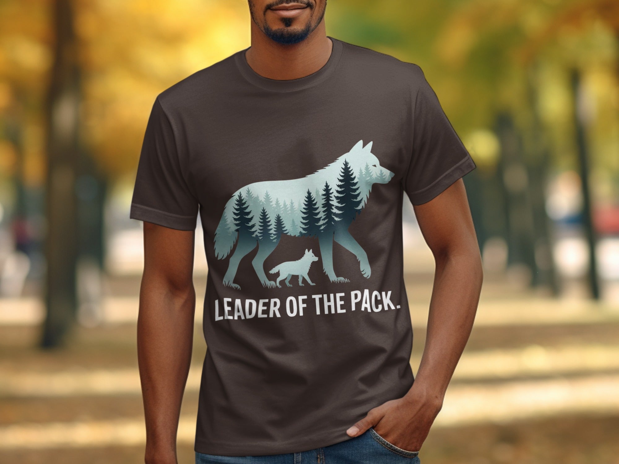 Dark brown t-shirt featuring a wolf silhouette filled with a forest landscape and text "LEADER OF THE PACK."