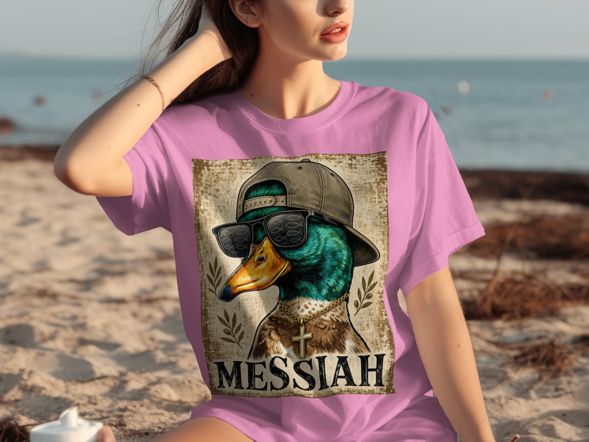 Duck wearing sunglasses and cross necklace with text MESSIAH on pink shirt.