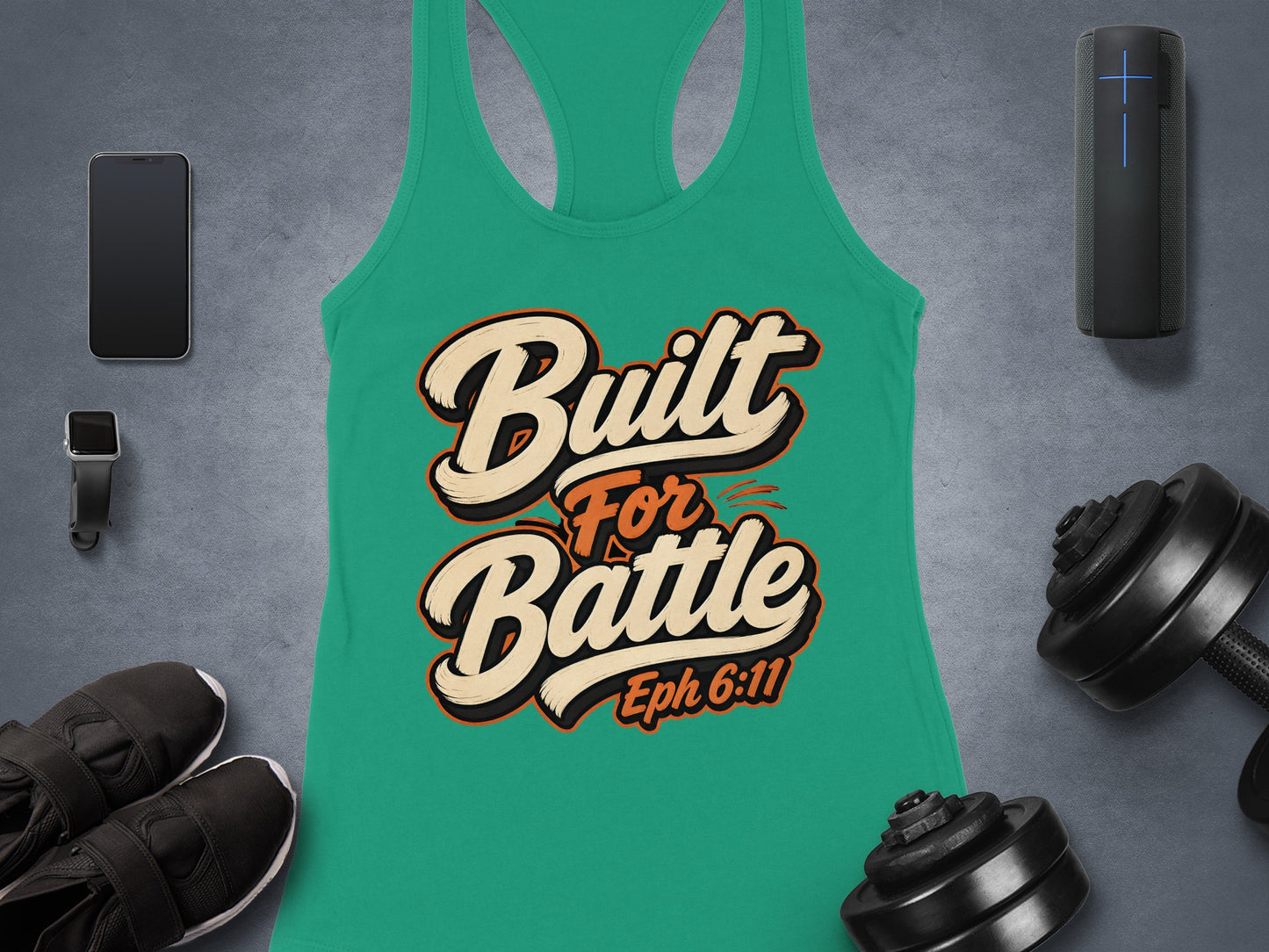 Green tank top with "Built For Battle Eph 6:11" text, surrounded by gym accessories.