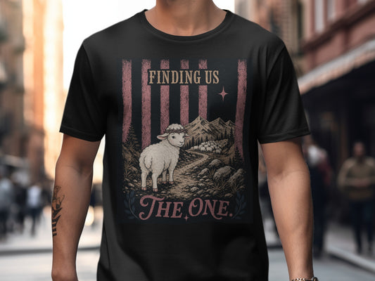 T-shirt graphic with sheep, mountains, and text "Finding Us The One".