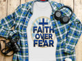 White t-shirt with blue text "FAITH OVER FEAR" and a cross graphic.