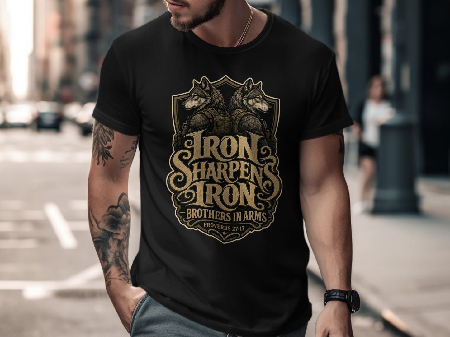 Black t-shirt with gold emblem featuring wolves, text "Iron Sharpens Iron", and "Brothers in Arms".