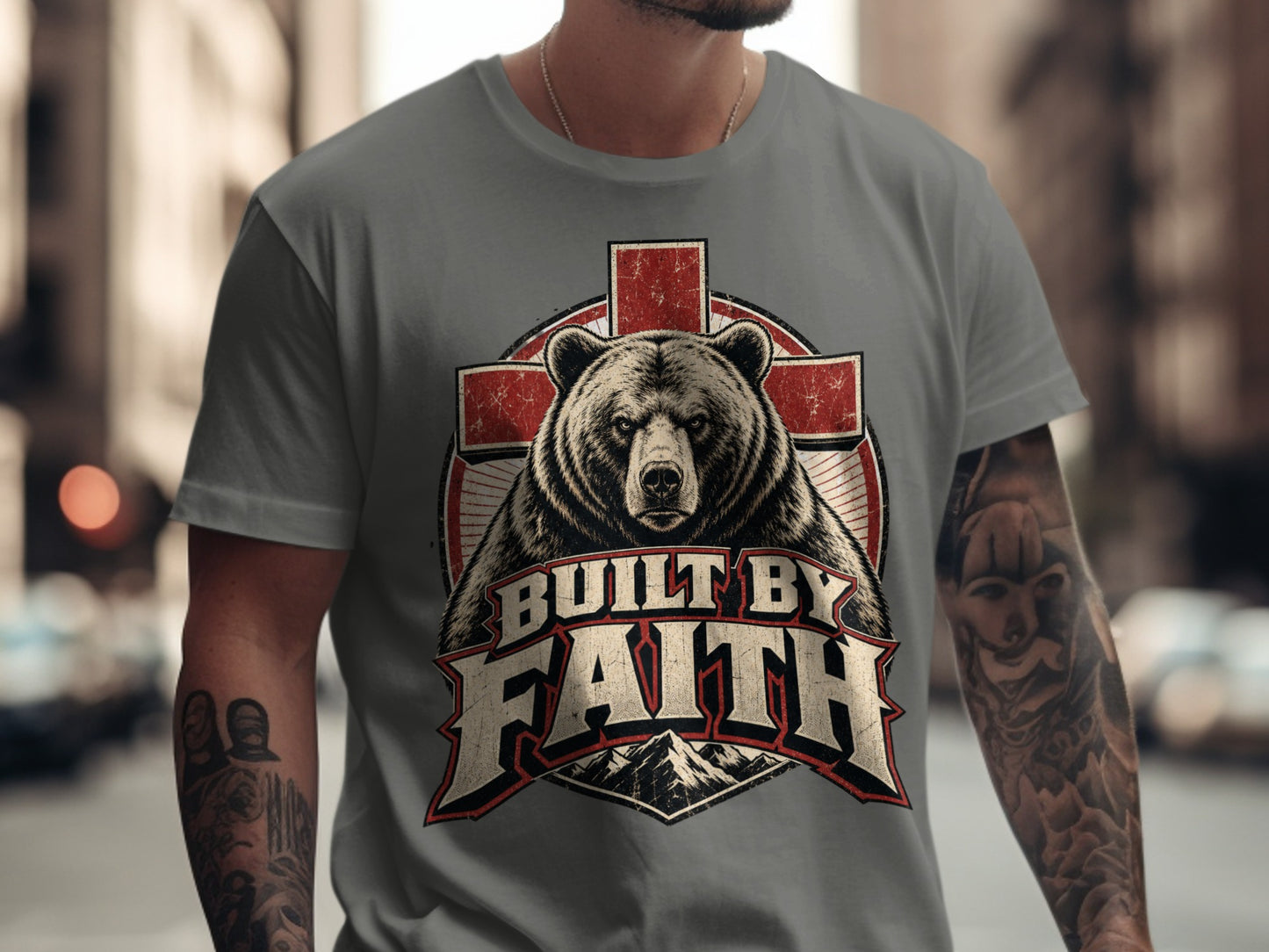 T-shirt graphic featuring a bear above text "Built by Faith" with mountains.