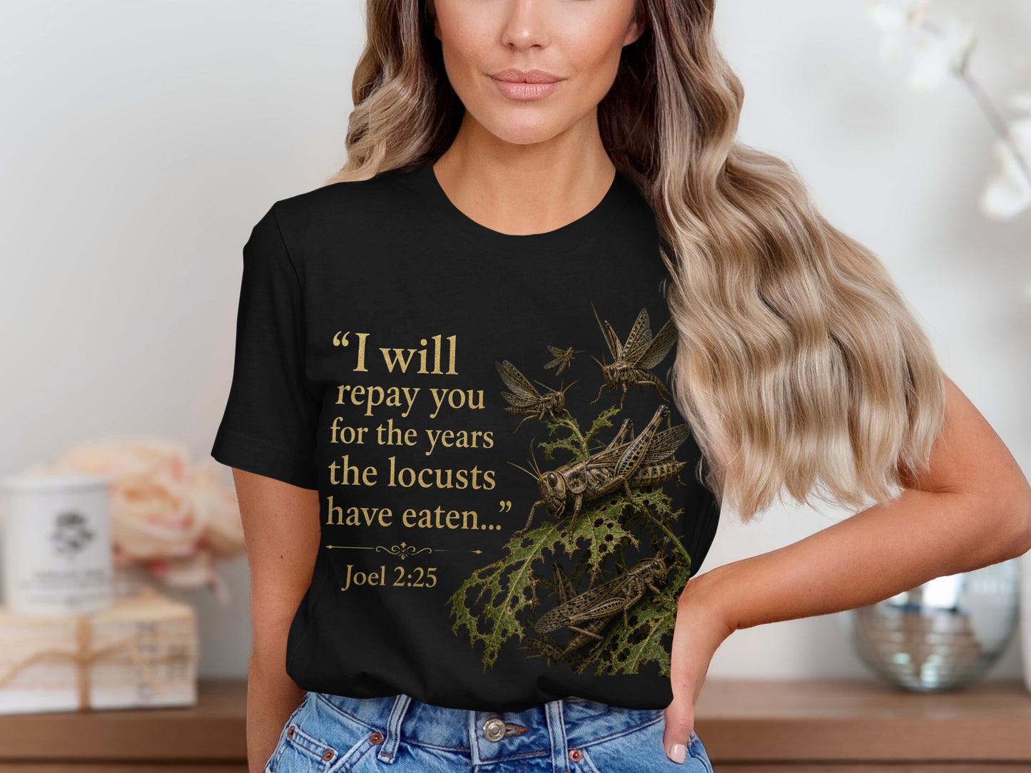 Black t-shirt with gold text and locusts on eaten leaves, Joel 2:25.