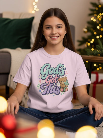 Girl wearing pink t-shirt with "God's Got This" text and teddy bear.