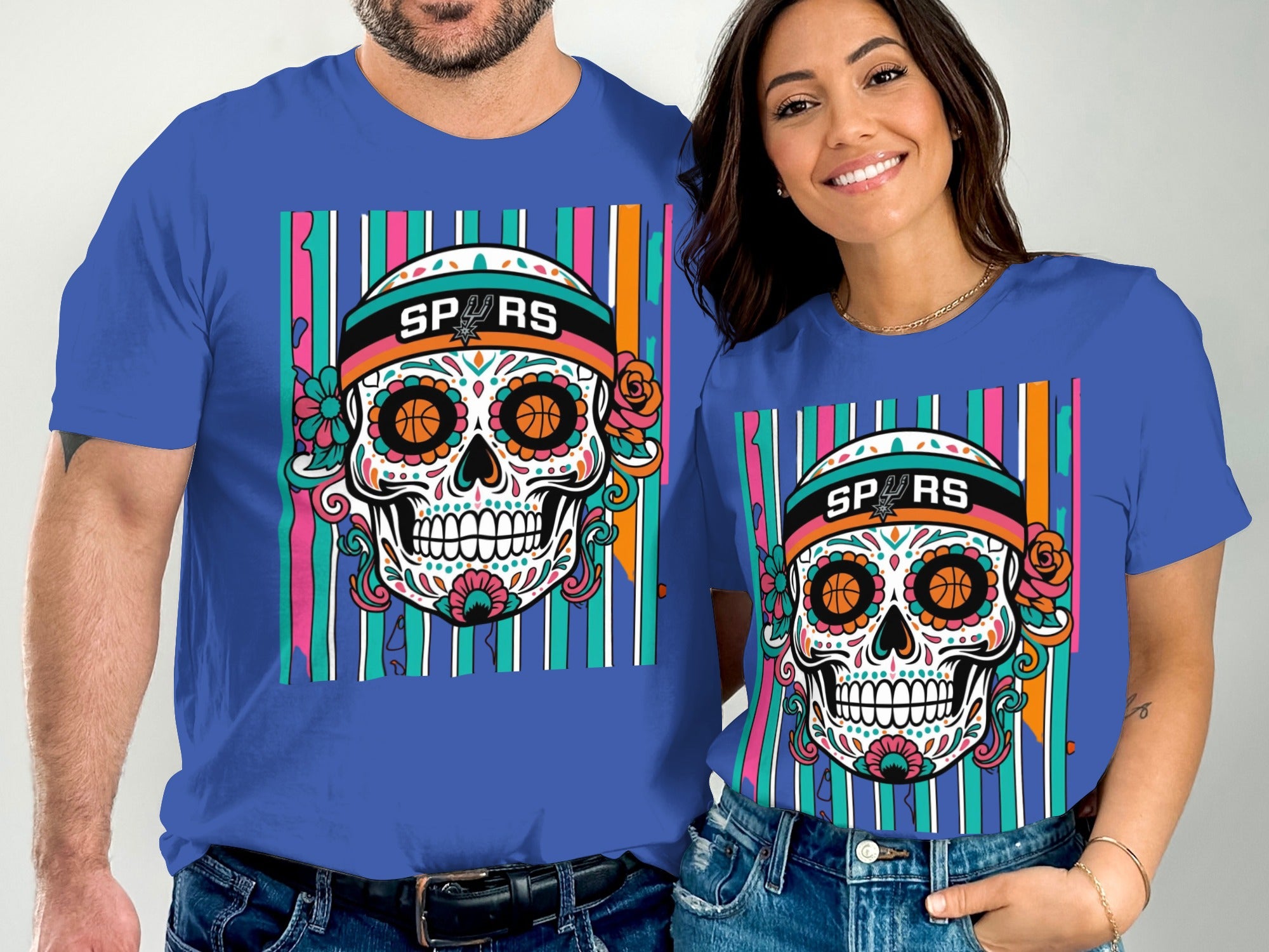 Couple wearing matching blue t-shirts with a sugar skull graphic and SPURS logo