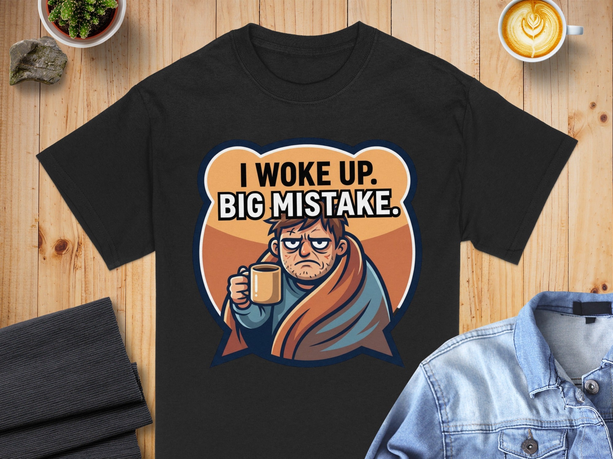 Black t-shirt with text "I WOKE UP. BIG MISTAKE." above grumpy man holding coffee.