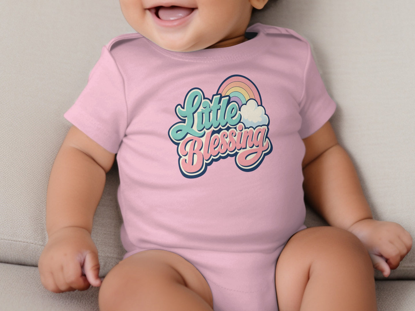 Baby in pink onesie with "Little Blessing" text and rainbow graphic.