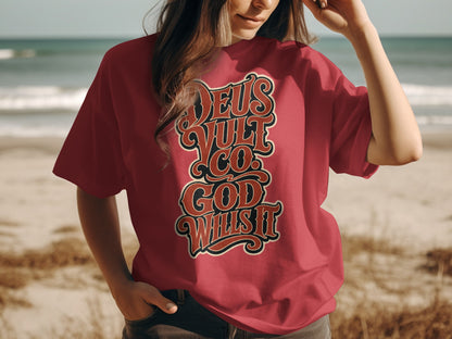 Red t-shirt with "Deus Vult Co. God Wills It" text on a beach background.