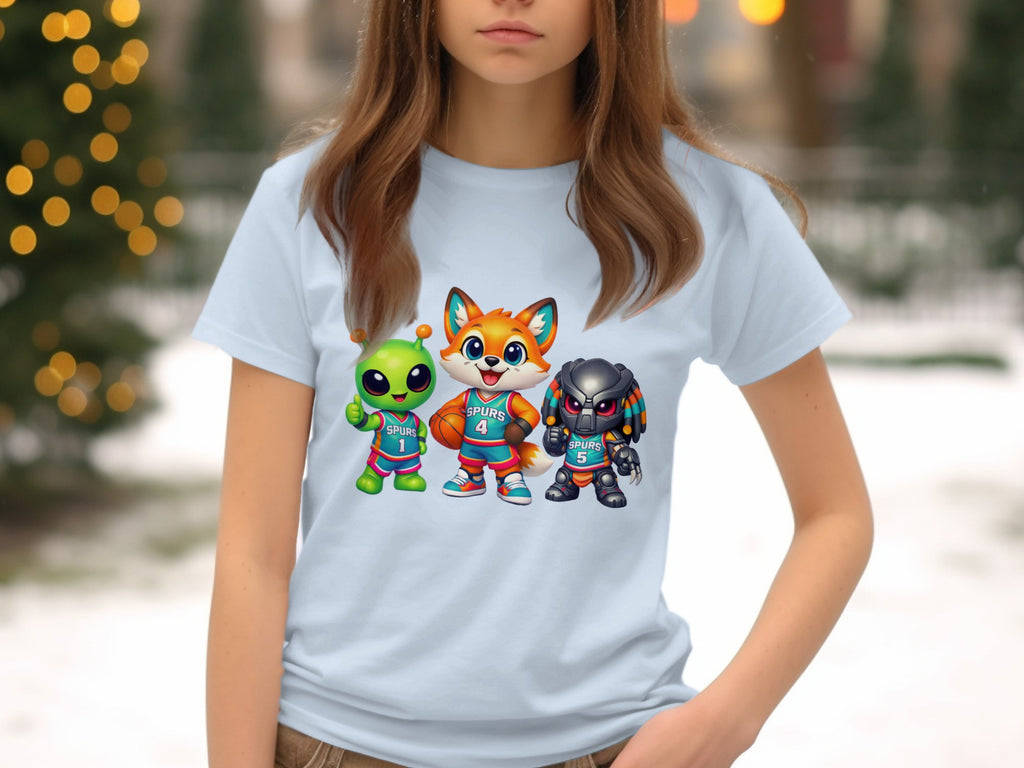 Light blue t-shirt with cartoon alien, fox, and predator characters playing basketball.