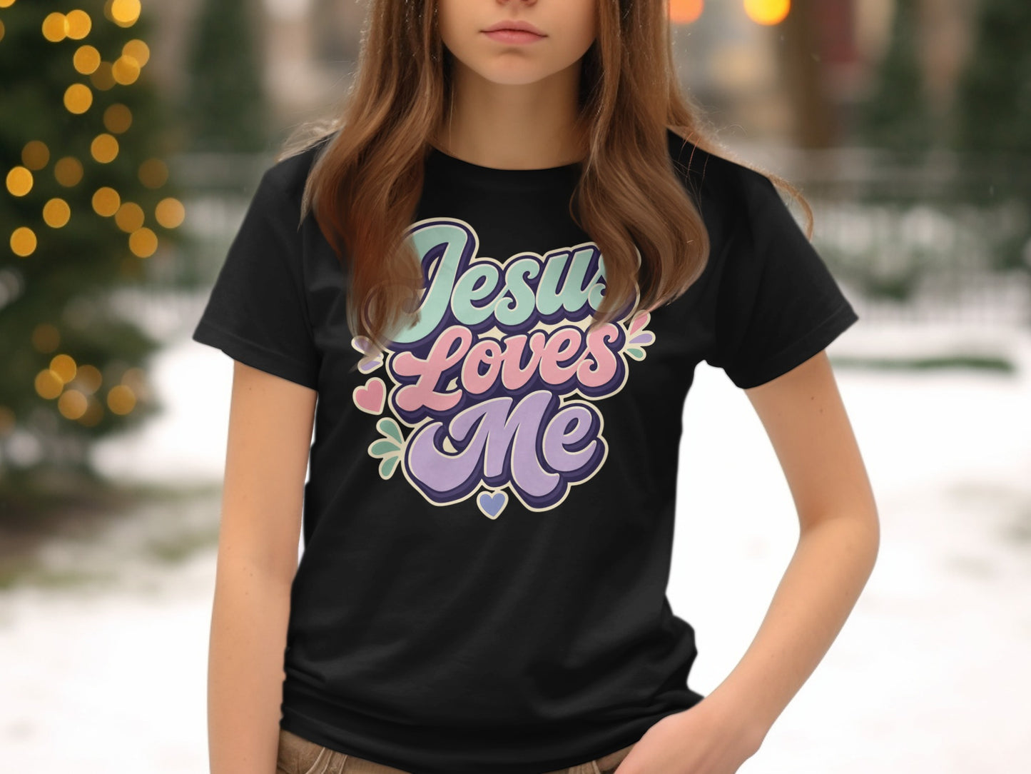 Black t-shirt featuring "Jesus Loves Me" text in pastel retro lettering.