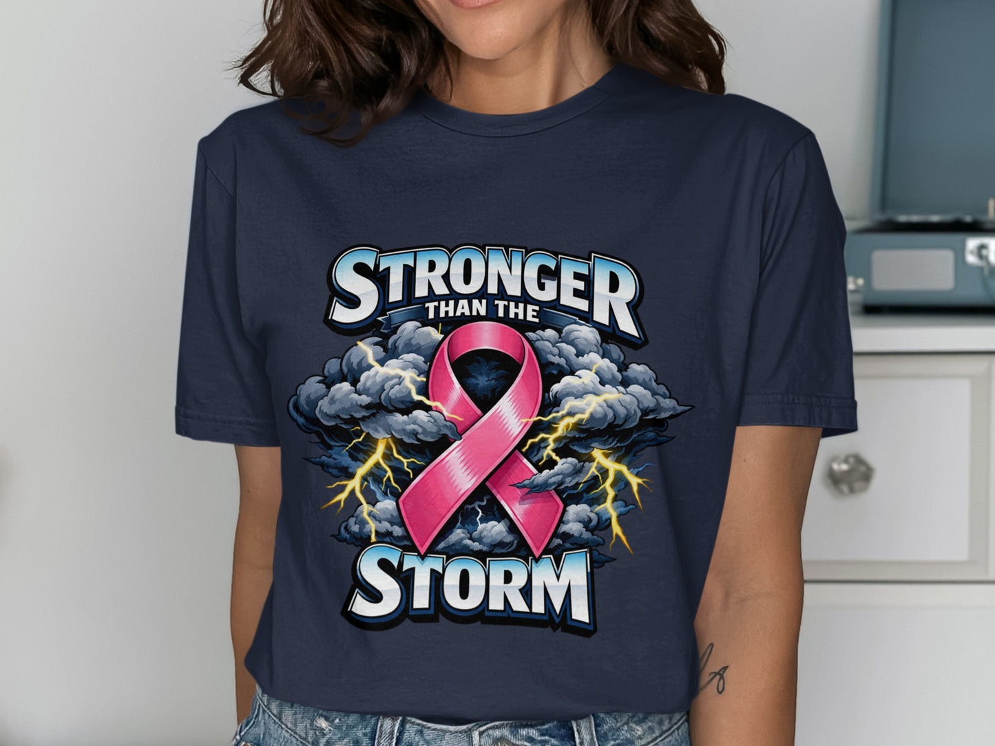 Navy t-shirt with graphic text "Stronger than the Storm" and pink ribbon.
