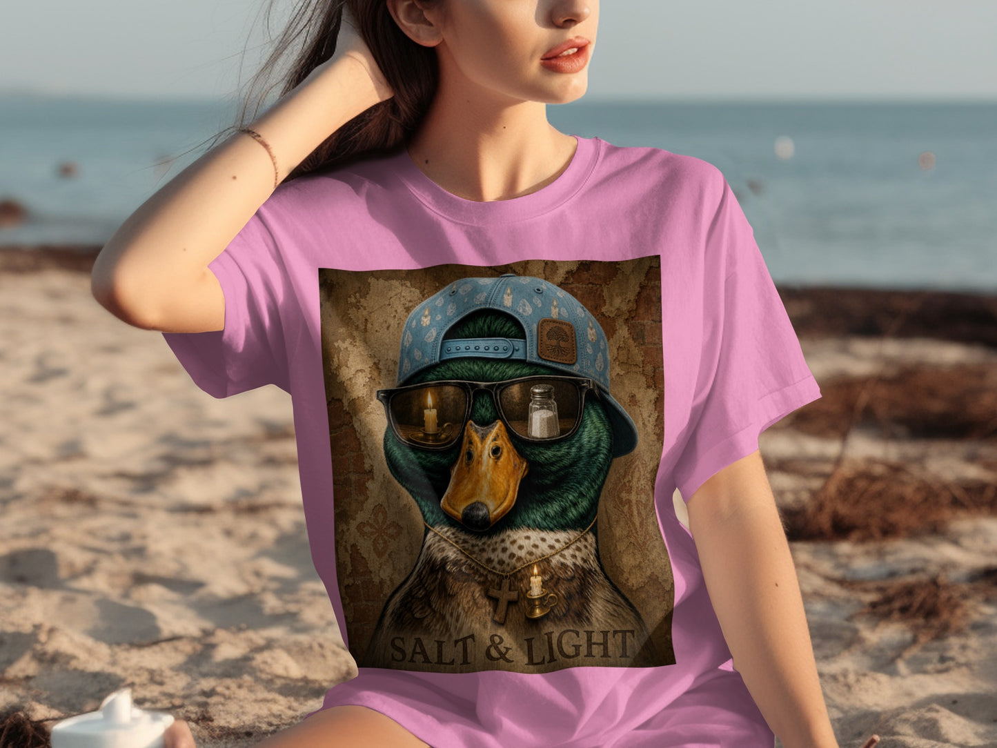 T-shirt graphic featuring a duck wearing sunglasses with a salt shaker and candle, and text "SALT & LIGHT".