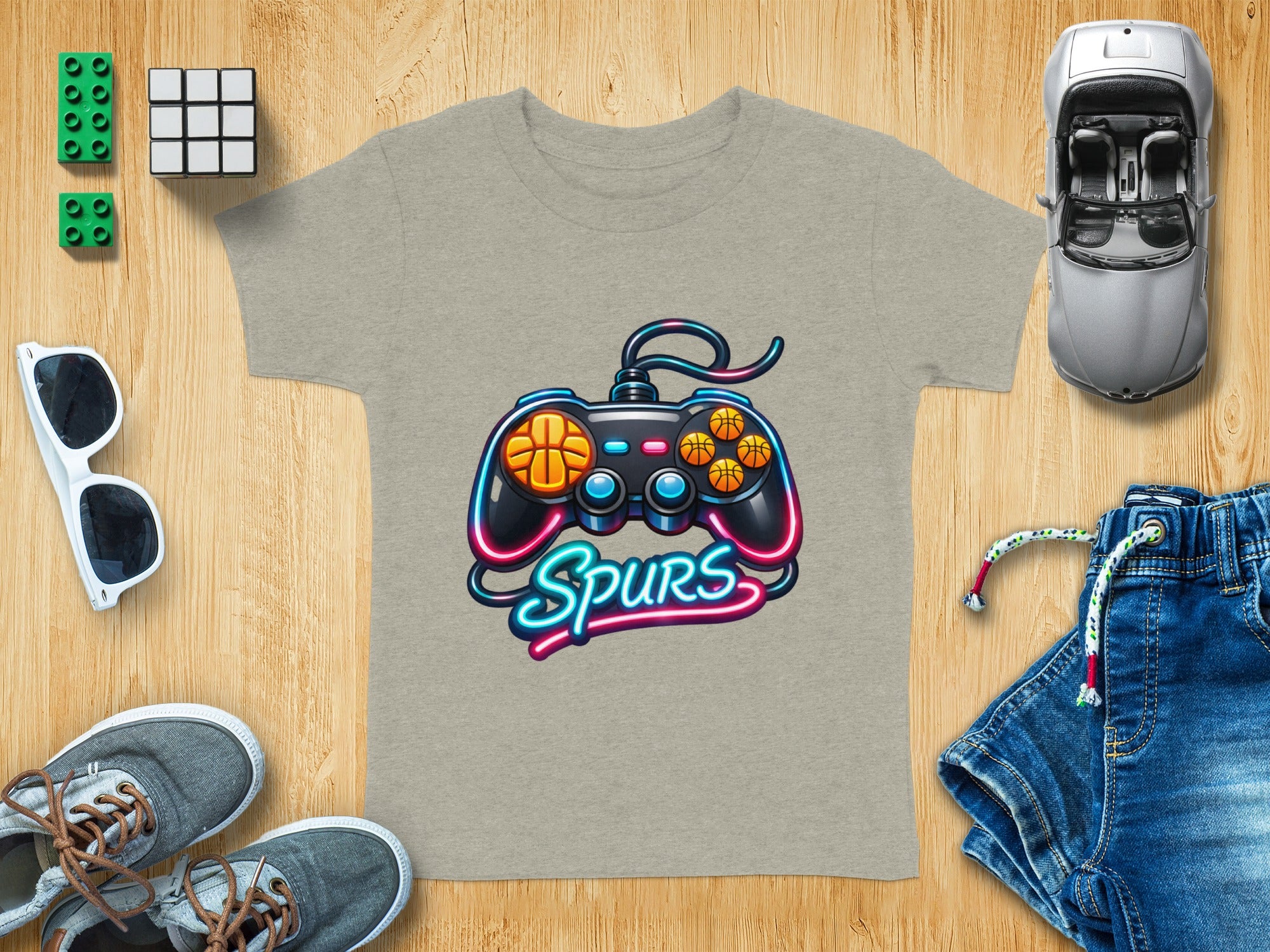 Gray t-shirt with a black video game controller graphic and neon "Spurs" text.