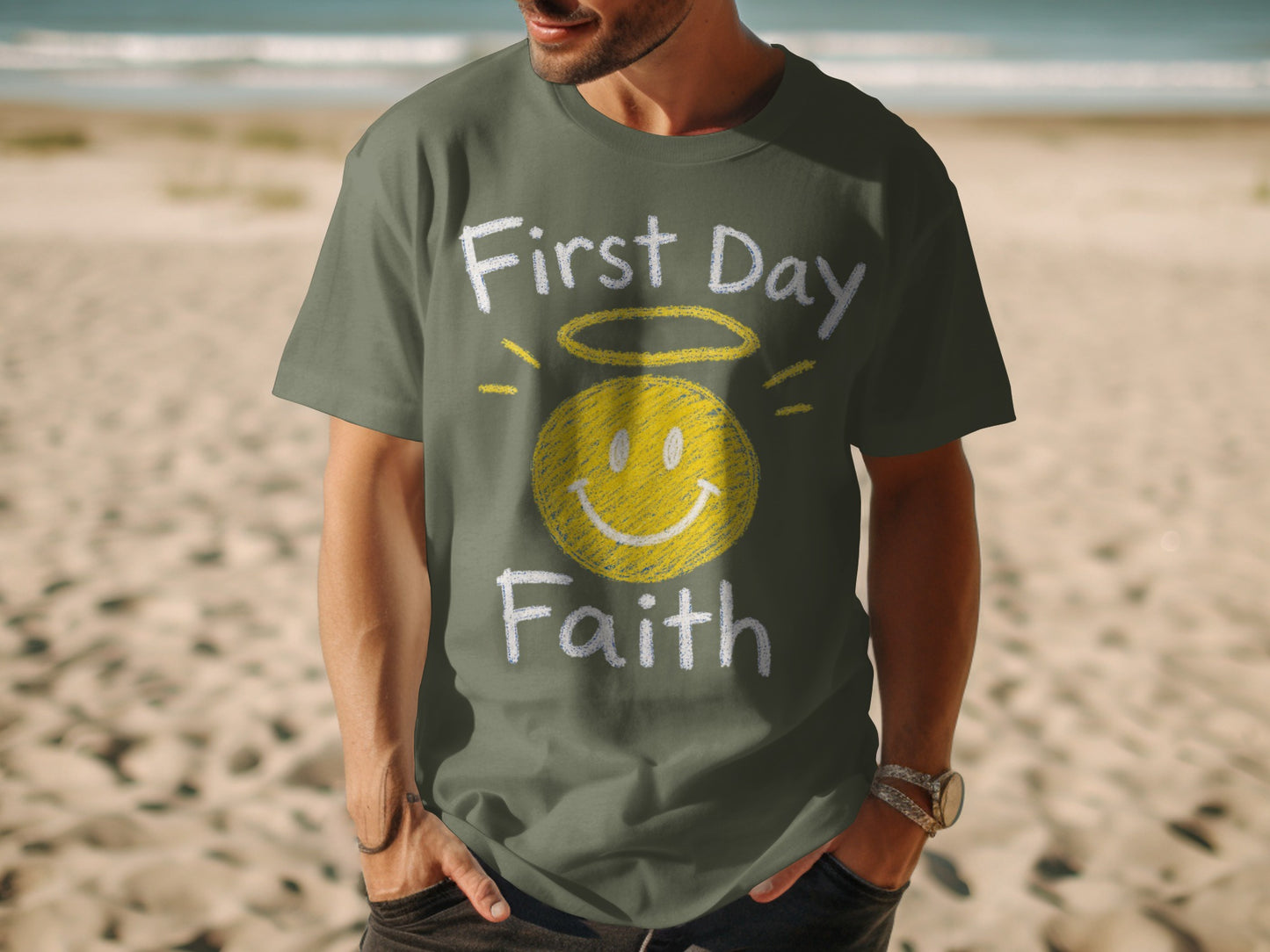 Olive t-shirt with "First Day Faith" and a smiley face with halo graphic.