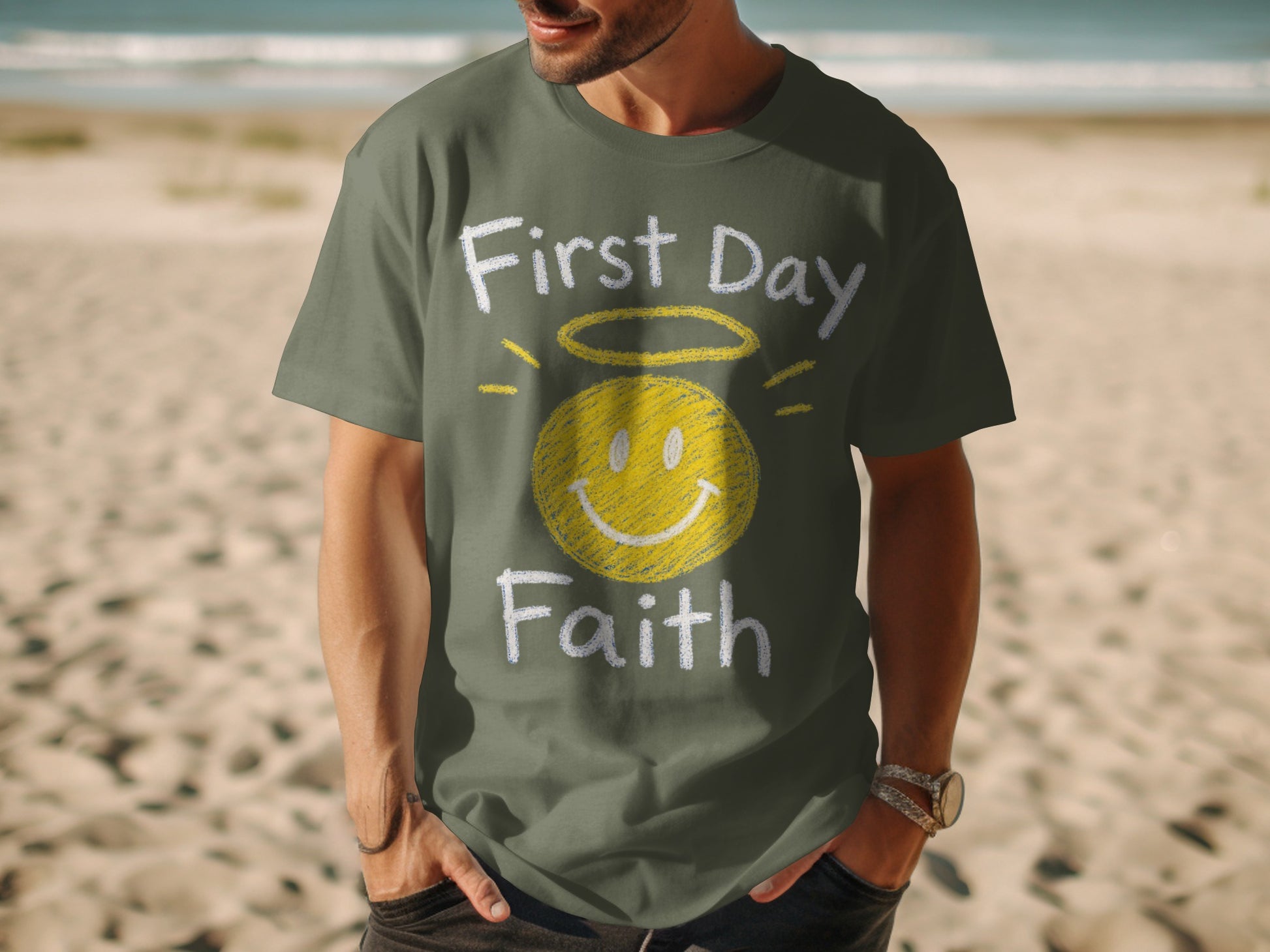 Olive t-shirt with "First Day Faith" and a smiley face with halo graphic.