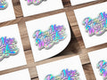 Holographic "Pray More, Worry Less" text on white cards on a wooden background.