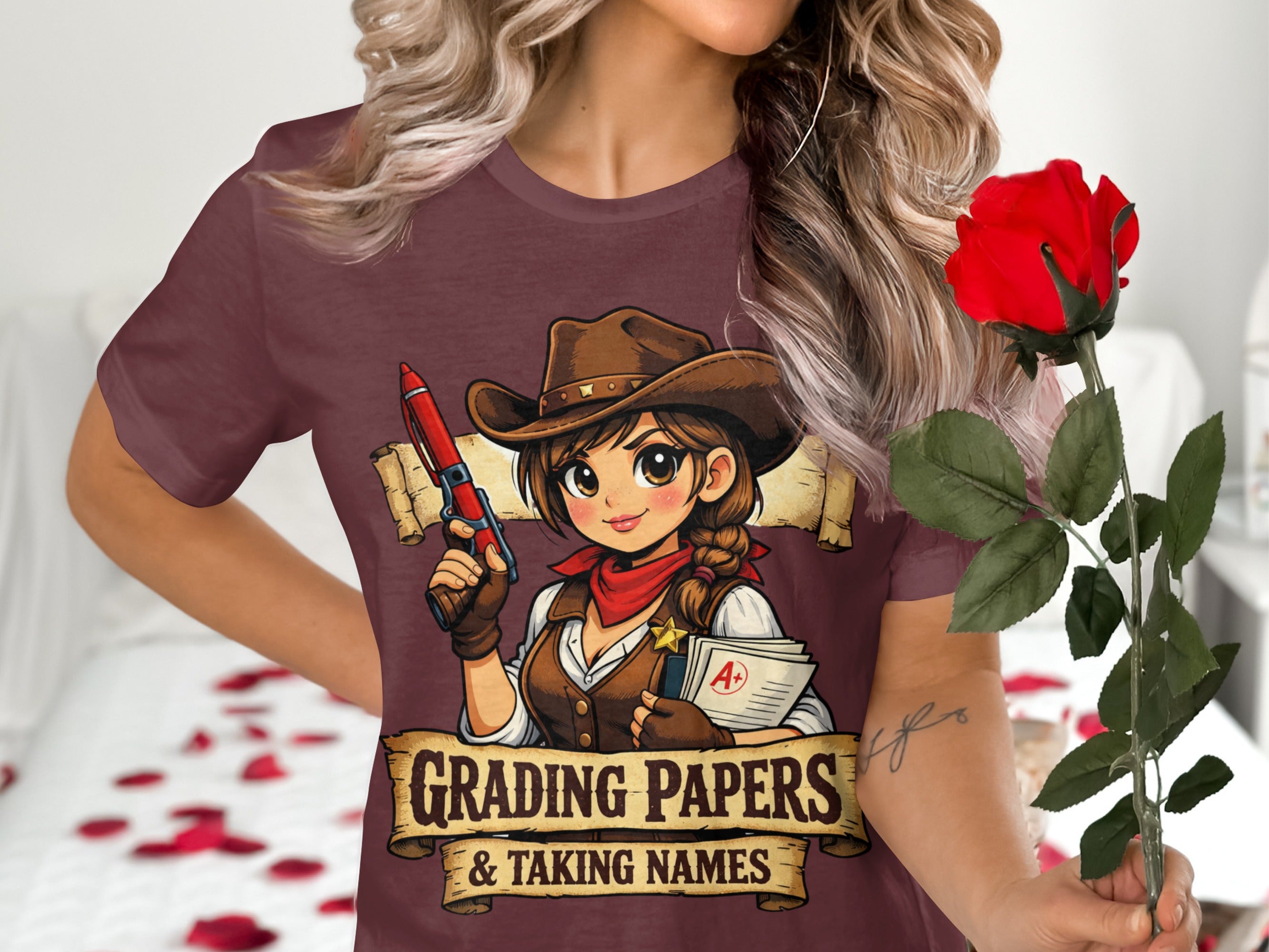 Maroon t-shirt featuring a cartoon cowgirl grading papers with text "Grading Papers & Taking Names."